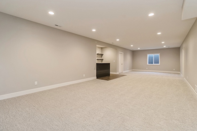 unfurnished living room featuring a fireplace and light carpet