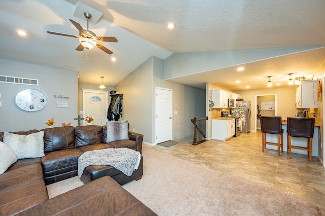 carpeted living room with ceiling fan, a textured ceiling, and vaulted ceiling