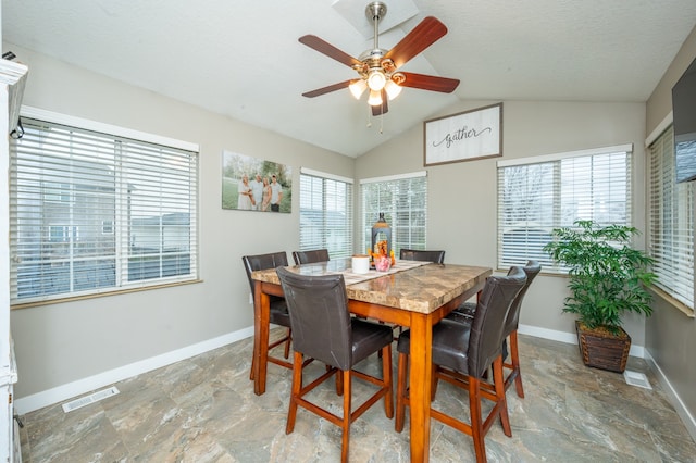 dining room featuring ceiling fan, lofted ceiling, and a textured ceiling