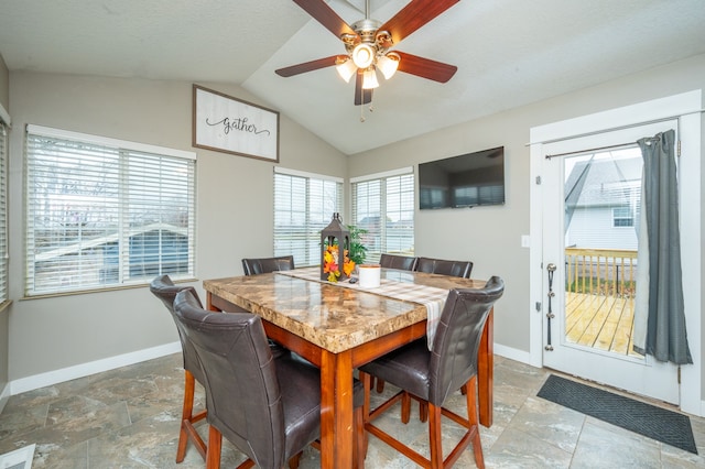 dining room featuring ceiling fan, a healthy amount of sunlight, and vaulted ceiling