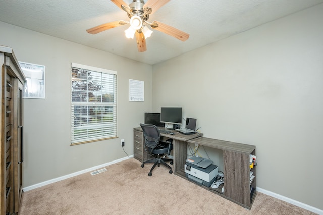 office space featuring ceiling fan, light colored carpet, and a textured ceiling