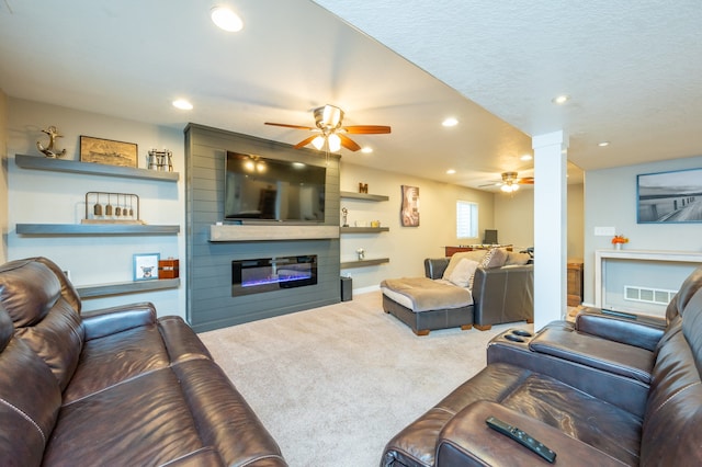 living room featuring carpet flooring, ceiling fan, and a large fireplace