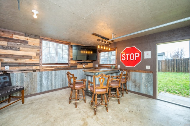 dining space featuring bar and plenty of natural light