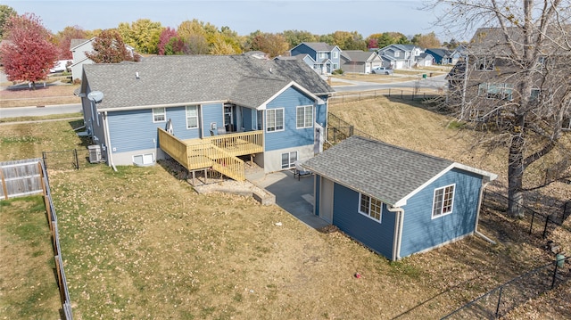 rear view of property featuring a lawn, central AC unit, and a wooden deck