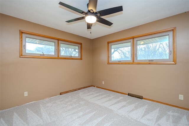 spare room with ceiling fan, carpet, and a healthy amount of sunlight