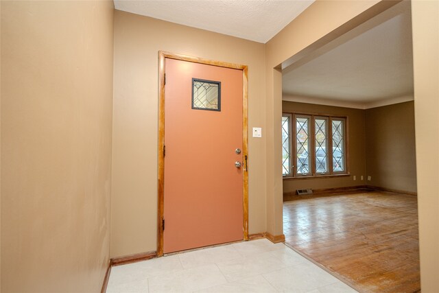 foyer entrance featuring light hardwood / wood-style floors and a textured ceiling