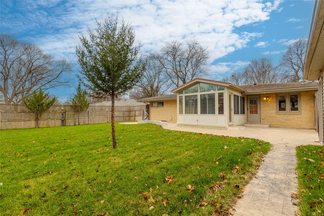 view of yard with a sunroom and a patio