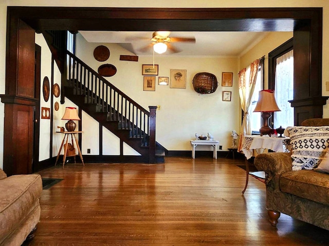 living room with ceiling fan, crown molding, and wood-type flooring