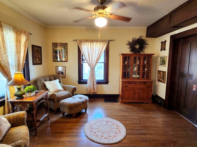 sitting room featuring dark hardwood / wood-style floors, ceiling fan, and crown molding