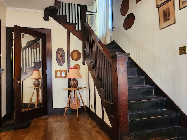 stairway featuring hardwood / wood-style floors and ornamental molding