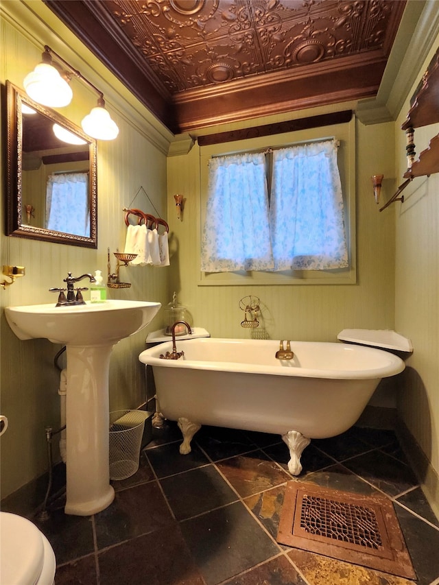 bathroom with tile patterned floors, sink, crown molding, toilet, and a tub