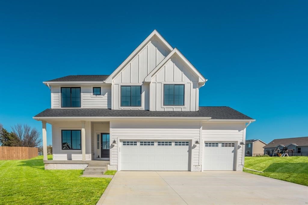 view of front of property featuring a garage, a front yard, and covered porch