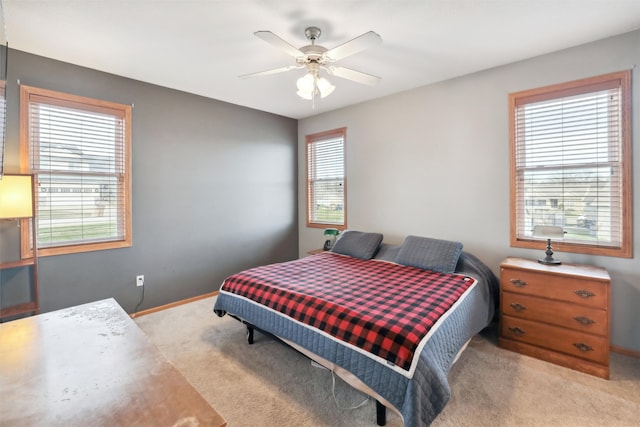 bedroom featuring light colored carpet, multiple windows, and ceiling fan