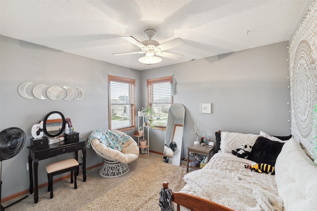 carpeted bedroom featuring ceiling fan and a textured ceiling