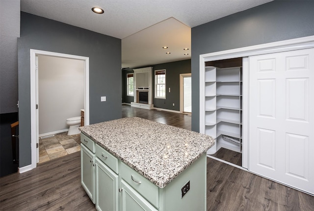 201 Elm Ave, Norwalk, IA 50211 - kitchen featuring a kitchen island, light stone countertops, dark wood-style floors, green cabinetry, and recessed lighting