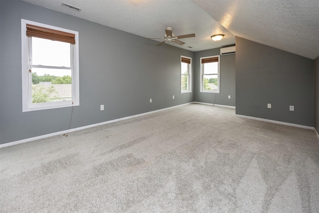201 Elm Ave, Norwalk, IA 50211 - spare room with a textured ceiling, a ceiling fan, carpet flooring, a wall unit AC, and lofted ceiling
