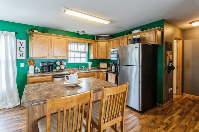 kitchen featuring sink, dark wood-type flooring, a textured ceiling, and appliances with stainless steel finishes