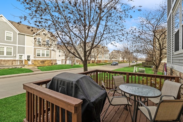 wooden deck featuring a yard and area for grilling