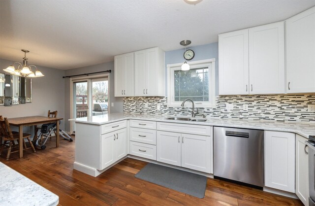 kitchen featuring dishwasher, sink, a notable chandelier, pendant lighting, and white cabinets