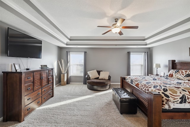 carpeted bedroom with multiple windows, a tray ceiling, and ceiling fan