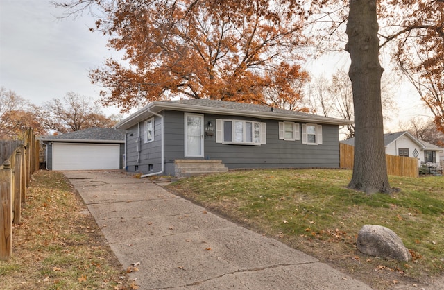 single story home with an outbuilding, a garage, and a front lawn