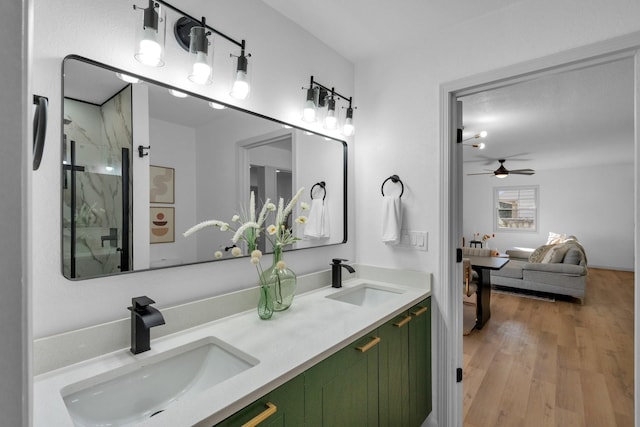 bathroom featuring ceiling fan, vanity, wood-type flooring, and walk in shower