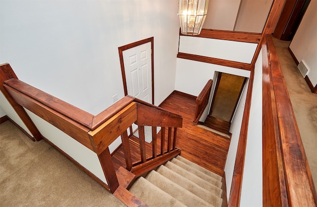 staircase featuring carpet flooring and an inviting chandelier