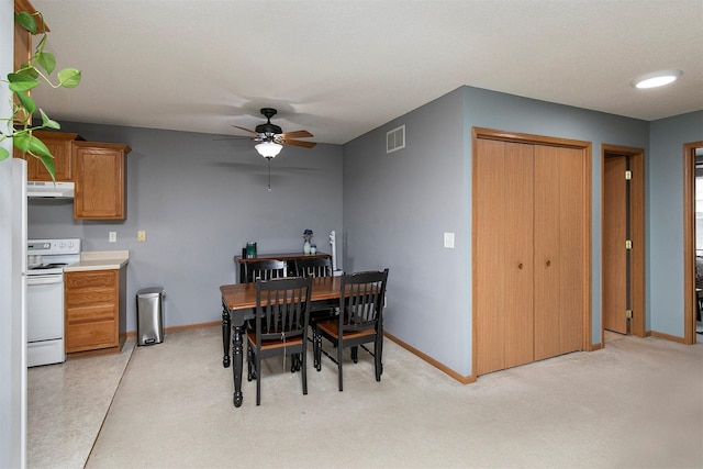 dining area with ceiling fan and light carpet