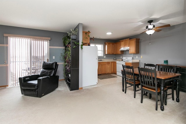 dining area featuring light carpet and ceiling fan