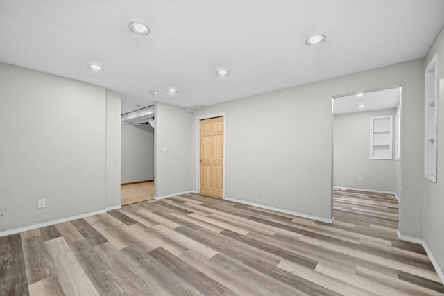 spare room featuring baseboards, wood finished floors, and recessed lighting