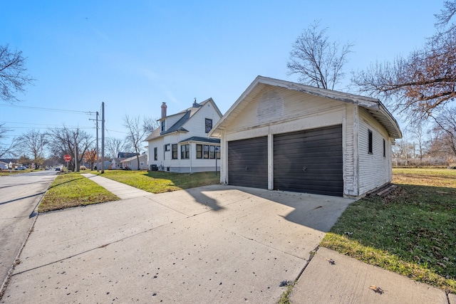 view of front facade with a garage, an outdoor structure, and a front lawn