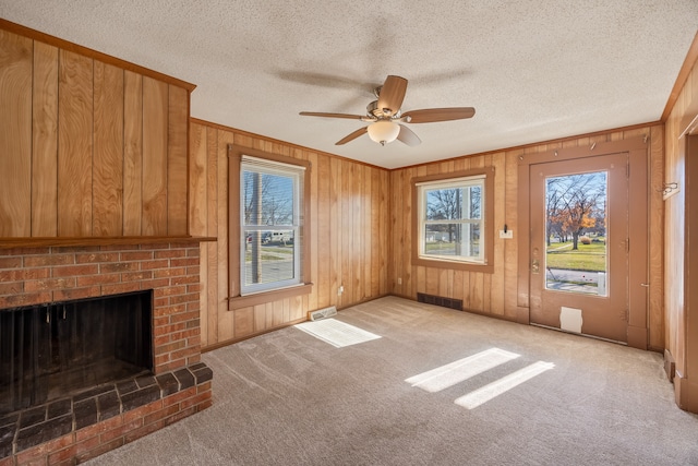 unfurnished living room with carpet floors, ceiling fan, and wooden walls