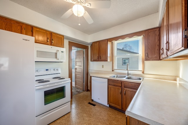 kitchen featuring a textured ceiling, white appliances, ceiling fan, and sink