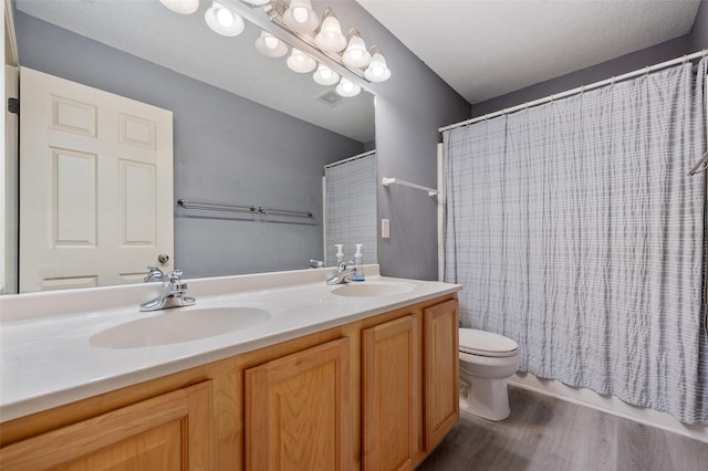 bathroom featuring toilet, vanity, and hardwood / wood-style floors