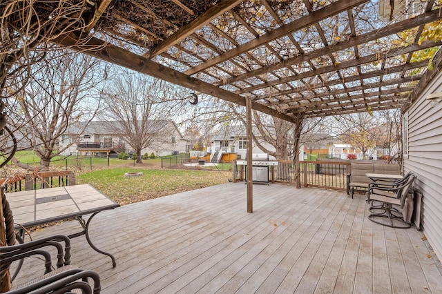 wooden deck featuring area for grilling, a pergola, and a yard