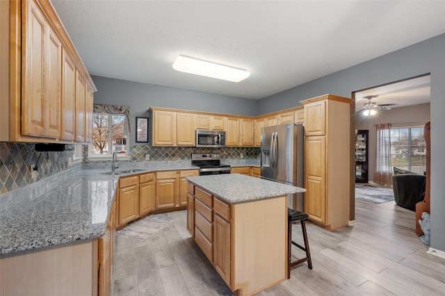 kitchen featuring stainless steel appliances, a center island, sink, and tasteful backsplash