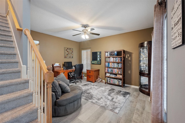 office with a textured ceiling, ceiling fan, and light hardwood / wood-style flooring