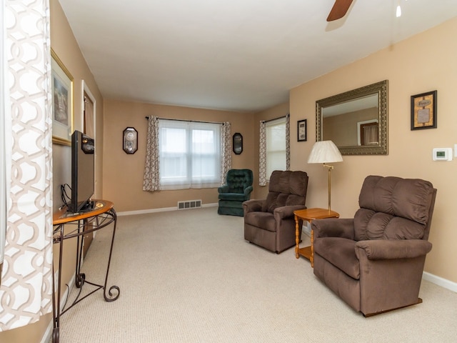 carpeted living room with ceiling fan