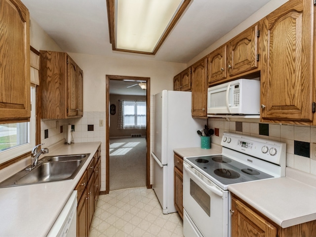 kitchen featuring decorative backsplash, white appliances, ceiling fan, and sink