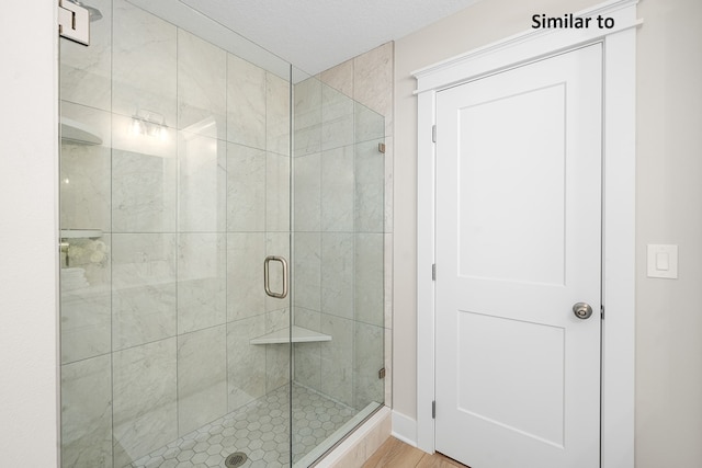 bathroom with hardwood / wood-style flooring and a shower with door