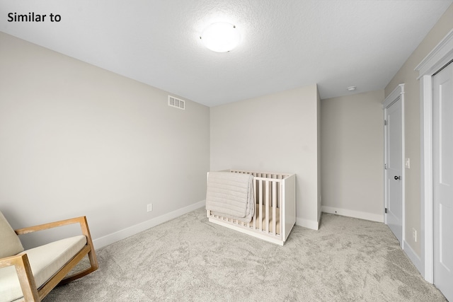 unfurnished bedroom with a textured ceiling and light carpet