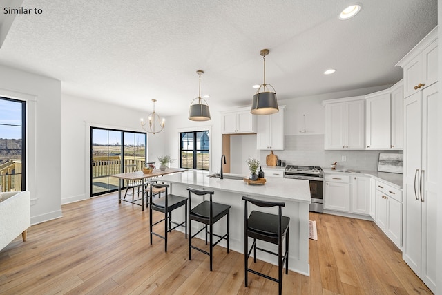 kitchen featuring light hardwood / wood-style flooring, white cabinets, and stainless steel range oven