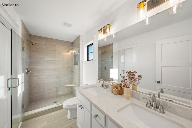 bathroom with tile patterned floors, vanity, toilet, and an enclosed shower