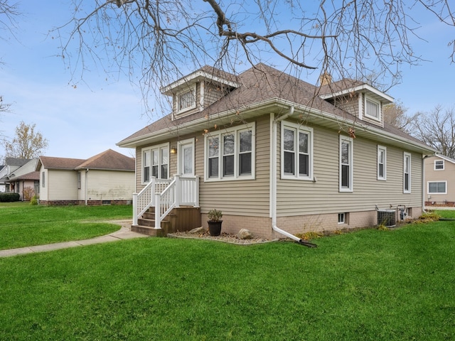 view of front of house with central air condition unit and a front lawn