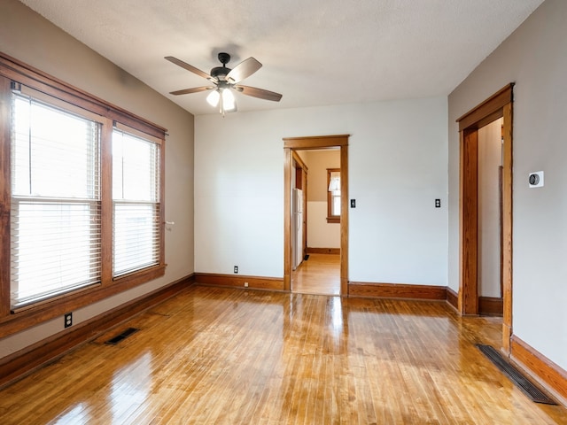 spare room featuring a textured ceiling, light wood-type flooring, and ceiling fan