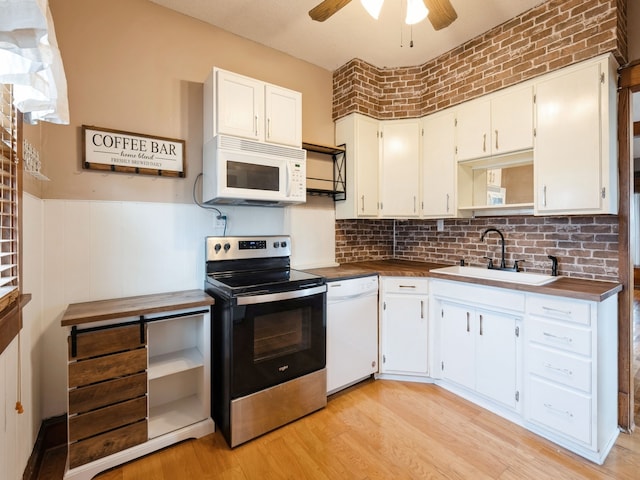 kitchen featuring white cabinets, light wood-type flooring, white appliances, and sink