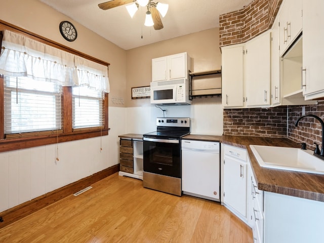 kitchen with white appliances, ceiling fan, sink, light hardwood / wood-style flooring, and white cabinetry