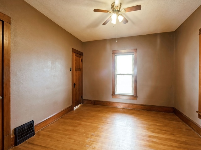 spare room with ceiling fan, light hardwood / wood-style floors, and a textured ceiling