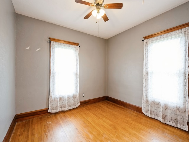 unfurnished room with hardwood / wood-style flooring, ceiling fan, and a healthy amount of sunlight