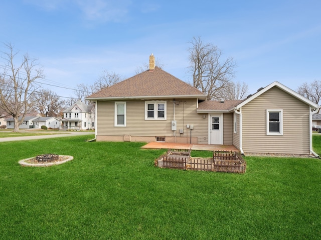 rear view of property with a lawn, a patio area, and a fire pit